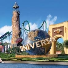 Alt text: "Universal Studios entrance with iconic globe and roller coasters in background under a clear blue sky. Lush greenery adds a vibrant, inviting feel."